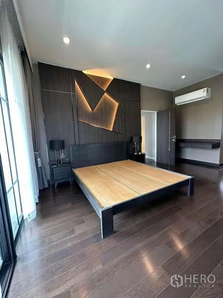 独立式住宅 出售在Prawet, Bangkok - 主卧，几何灯光背景墙、平台床并可通往阳台。