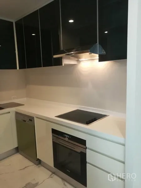 คอนโด ให้เช่าในPathum Wan, Bangkok - ครัวโมเดิร์นพร้อมเตาอินดักชัน เตาอบ เครื่องล้างจาน และตู้แขวนเงามันวาว