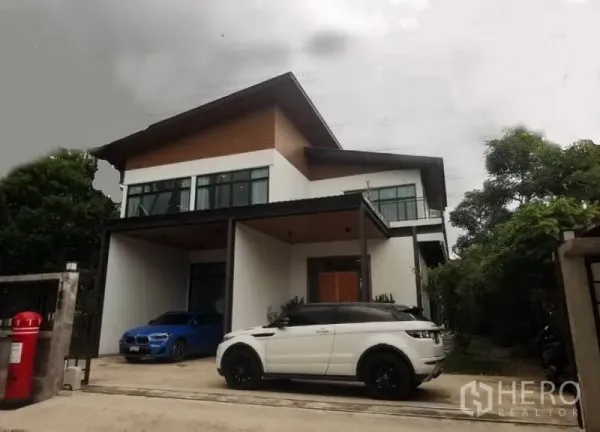 Detached House for sale in Pak Kret, Nonthaburi - Front elevation of the detached house with sloped roof, balcony and two-car parking.
