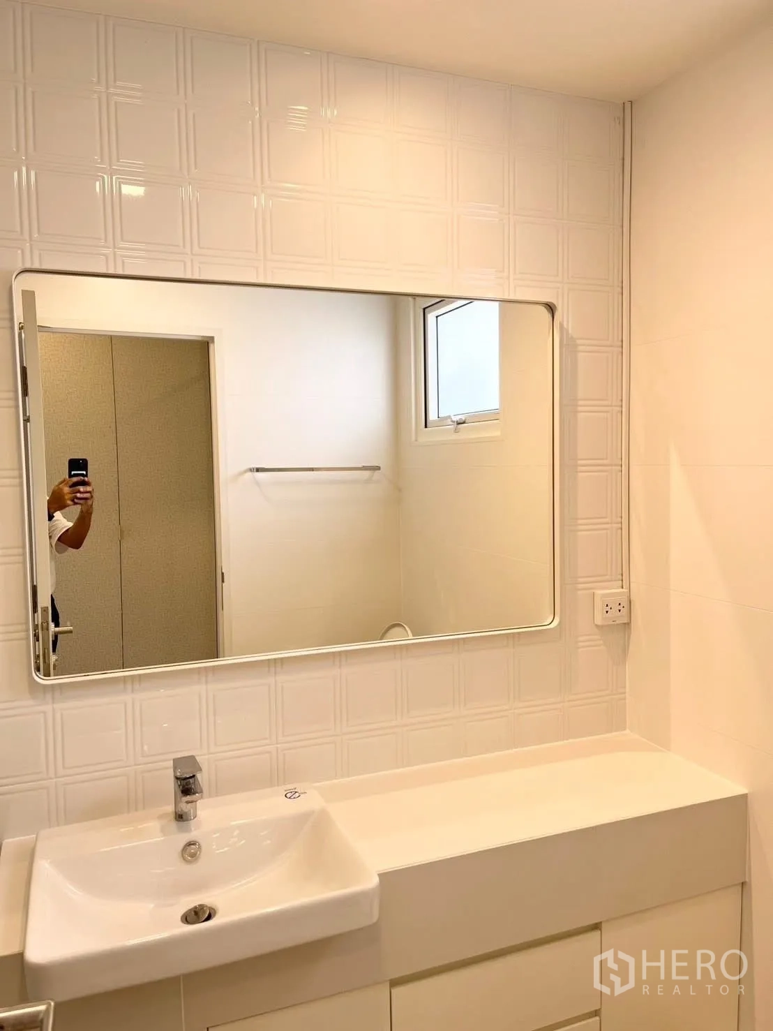 Detached House for rent in Bang Phli, Samut Prakan - Clean bathroom vanity with rectangular sink, wide mirror, and a small window.