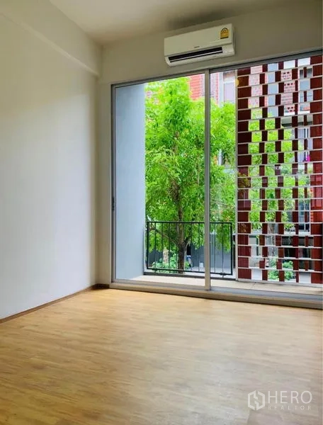 Home Office for rent - Bedroom with sliding glass door to balcony, red brick lattice and leafy view.