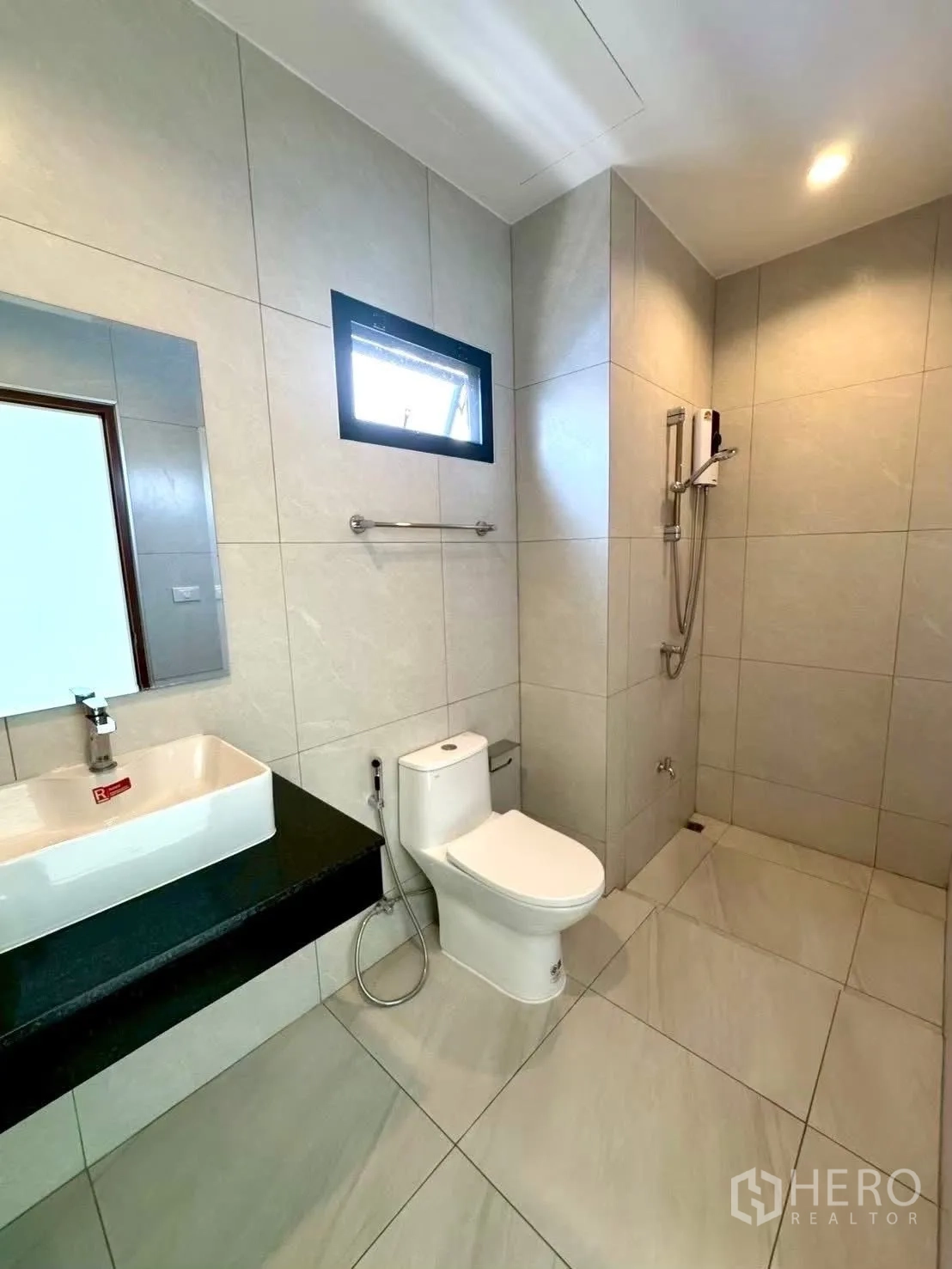 Home Office for rent in Wang Thonglang, Bangkok - Spacious bathroom showing sink counter, toilet, and open shower area.