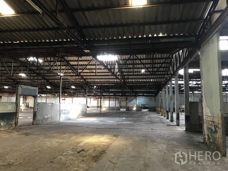 Land for rent in Phra Pradaeng, Samut Prakan - Large factory space under corrugated roof with wide clear spans and loading zones.