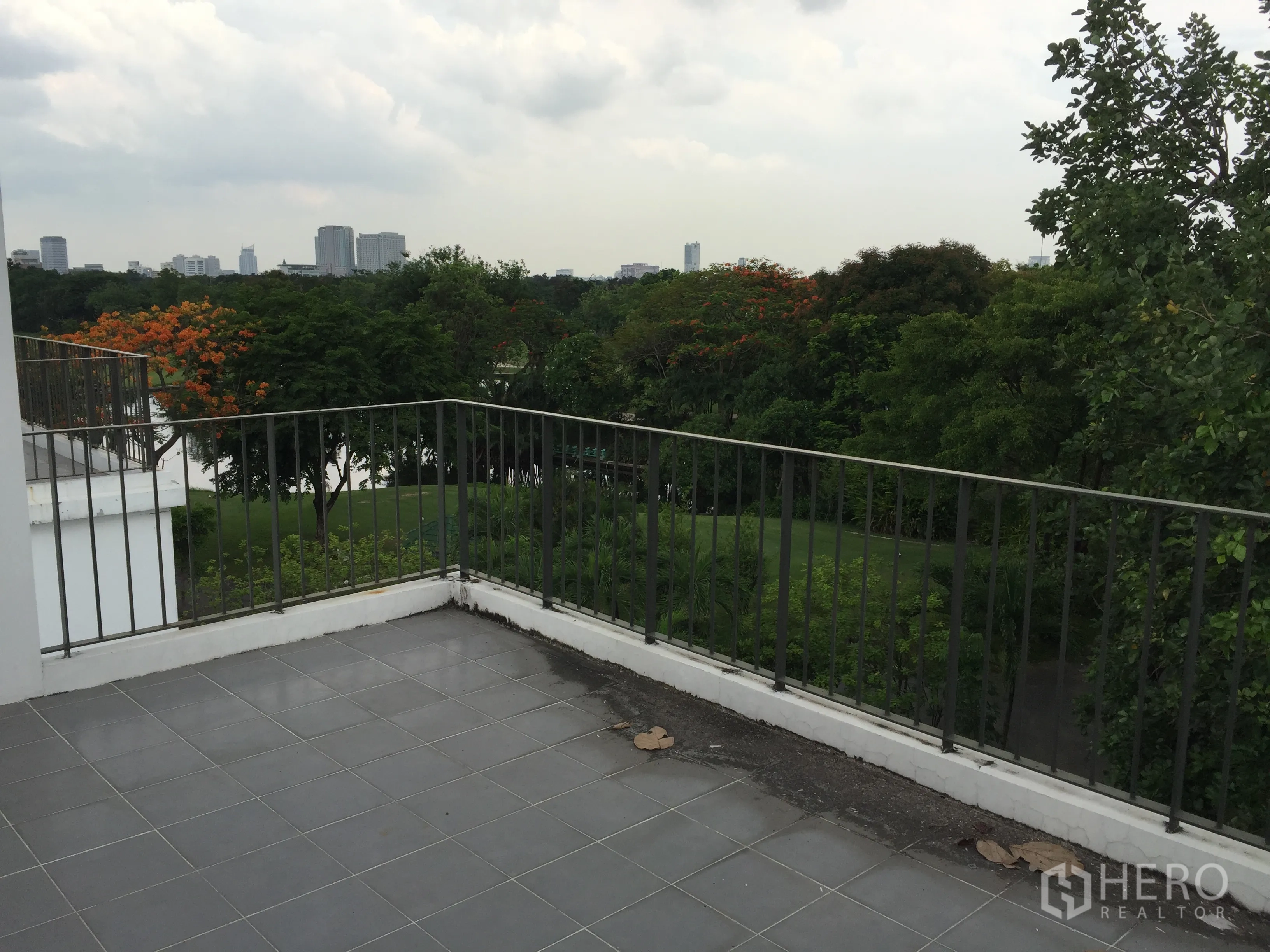 Townhouse for rent in Bang Kapi, Bangkok - Rooftop terrace with tiled floor and views of trees and Bangkok skyline.