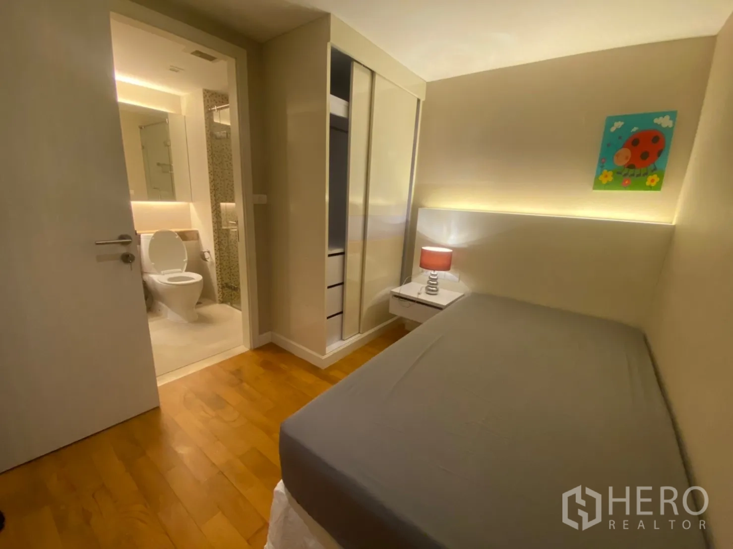 公寓 出租在Watthana, Bangkok - 小卧室一角，可见床头柜、衣柜与通往套卫的门。