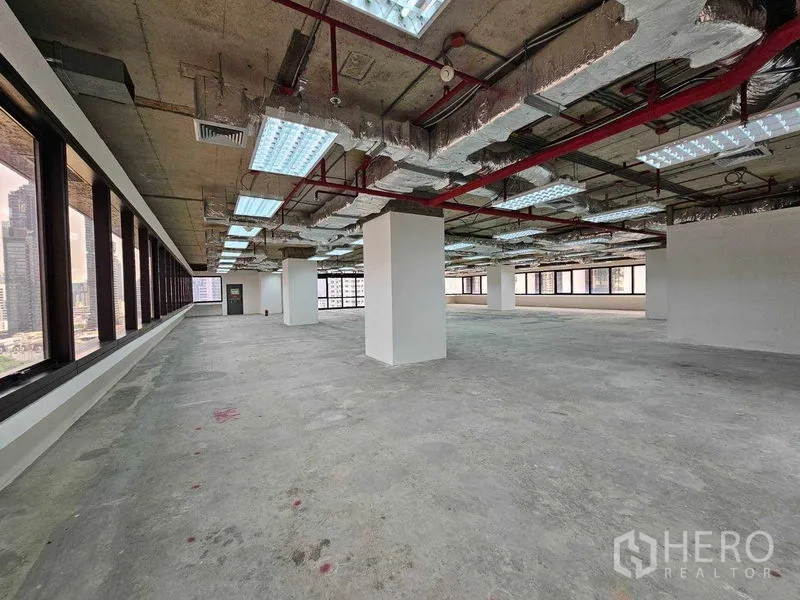 办公空间 出租在Bang Rak, Bangkok - 开放式办公室，四周采光窗与未铺装地面。