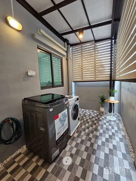 Townhouse for rent in Bang Phli, Samut Prakan - Covered laundry area with washing machine, dryer and patterned tiled floor.