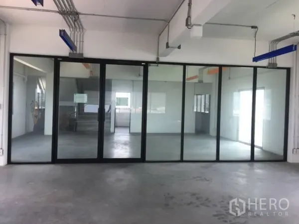 Home Office for rent or sale in Wang Thonglang, Bangkok - Bright workspace with full-height glass walls and industrial ceiling pipes.