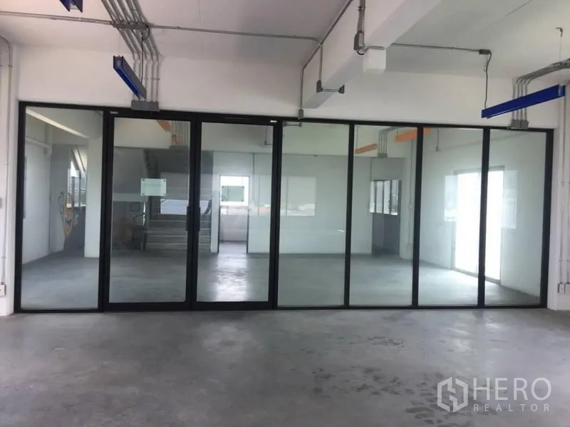 Home Office for rent or sale in Wang Thonglang, Bangkok - Bright workspace with full-height glass walls and industrial ceiling pipes.