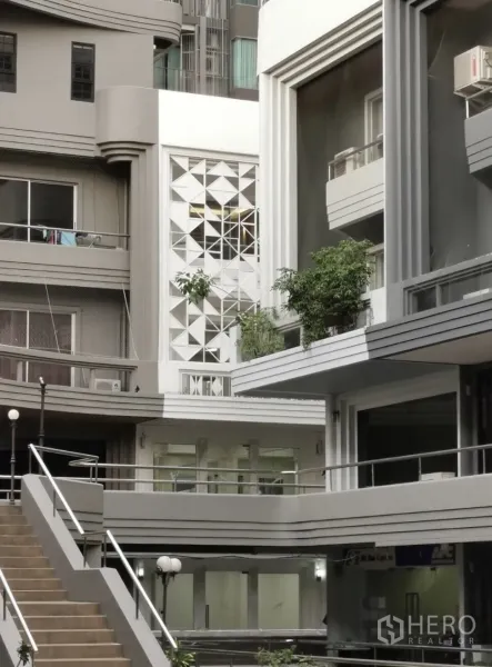 Home Office for rent in Watthana, Bangkok - Modern courtyard of a low-rise complex with geometric facade panels, balconies and stairways.