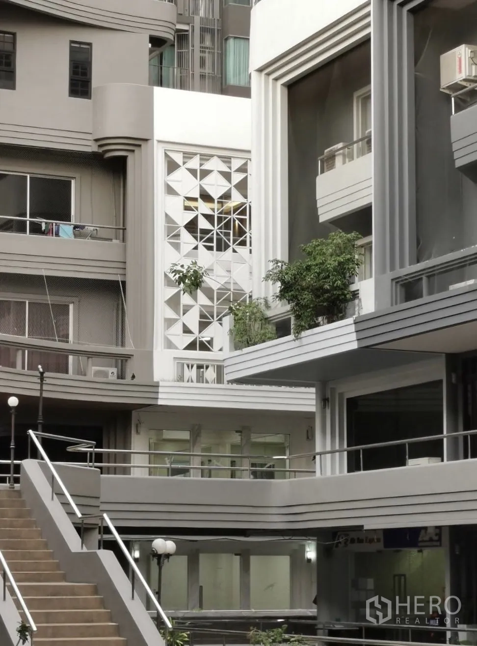 Home Office for rent in Watthana, Bangkok - Modern courtyard of a low-rise complex with geometric facade panels, balconies and stairways.