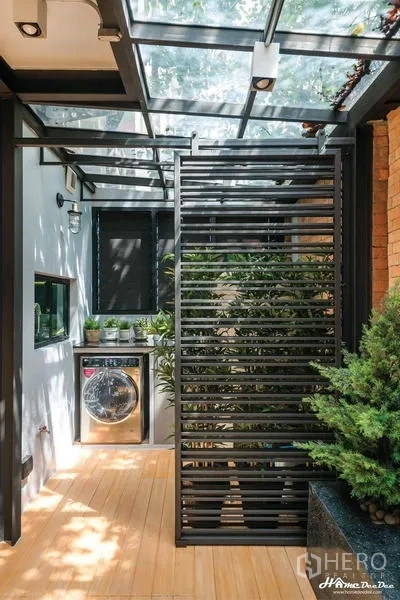 Townhouse for sale in Lak Si, Bangkok - Dining room with wooden table, three black pendants, and garden access.