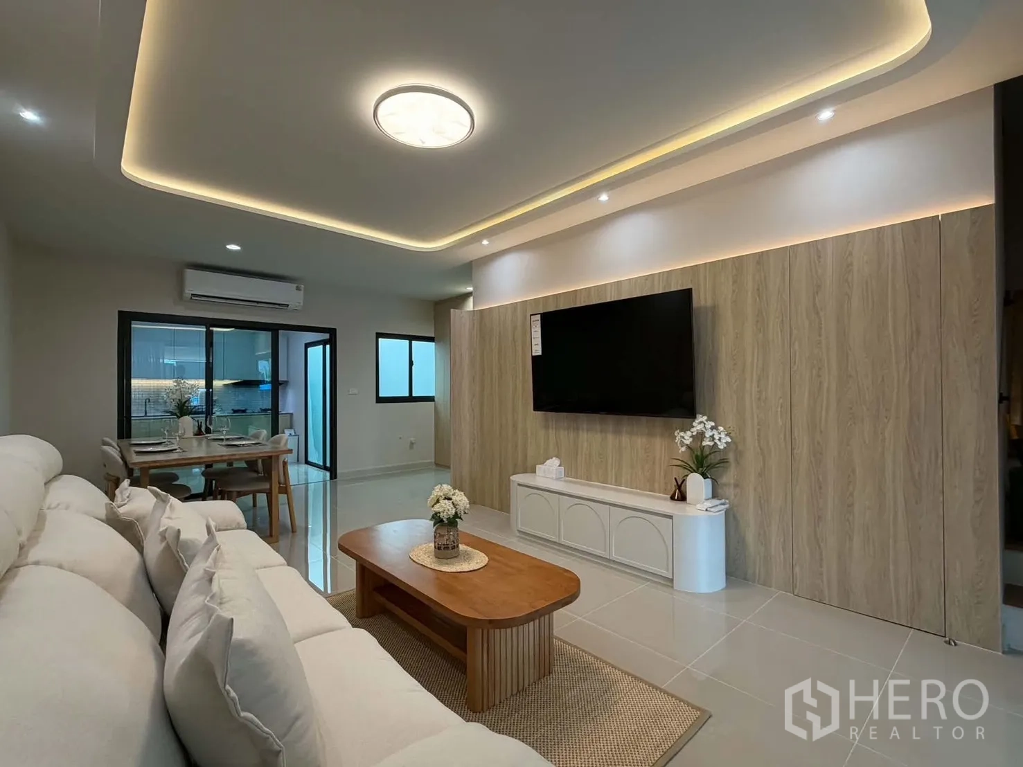 联排别墅 for rent in Bang Phli, Samut Prakan - 客厅设电视背景墙、嵌入式灯带与空调。