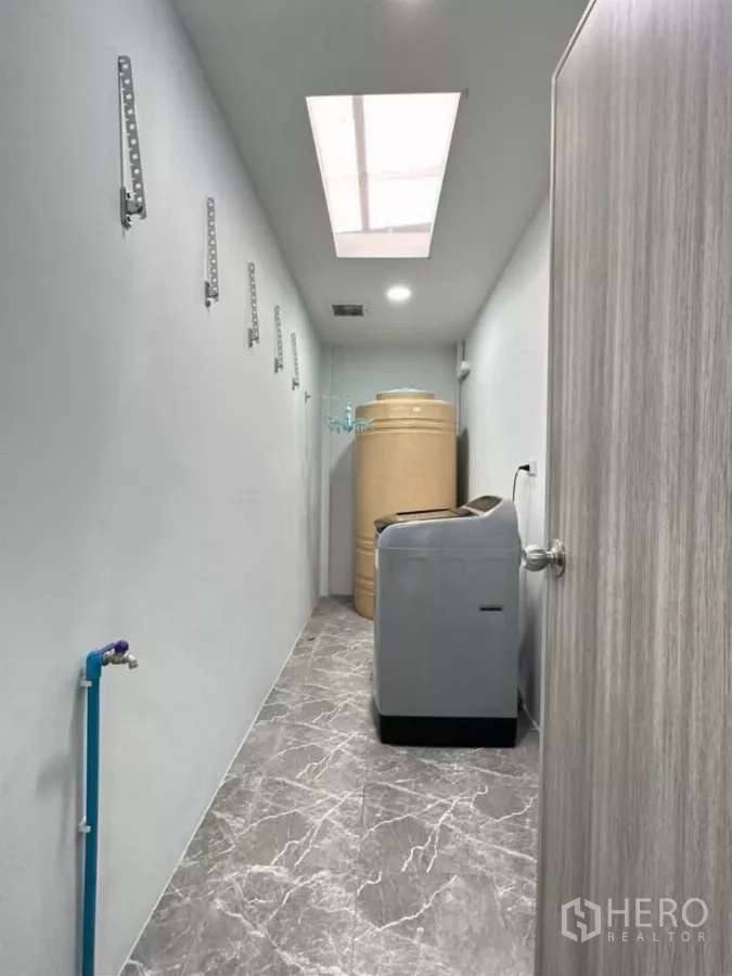 บ้าน ให้เช่าหรือขายในKhlong Toei, Bangkok - พื้นที่ซักล้างพร้อมเครื่องซักผ้า แท็งก์น้ำ สกายไลท์ และพื้นลายหินอ่อนสีเทา.