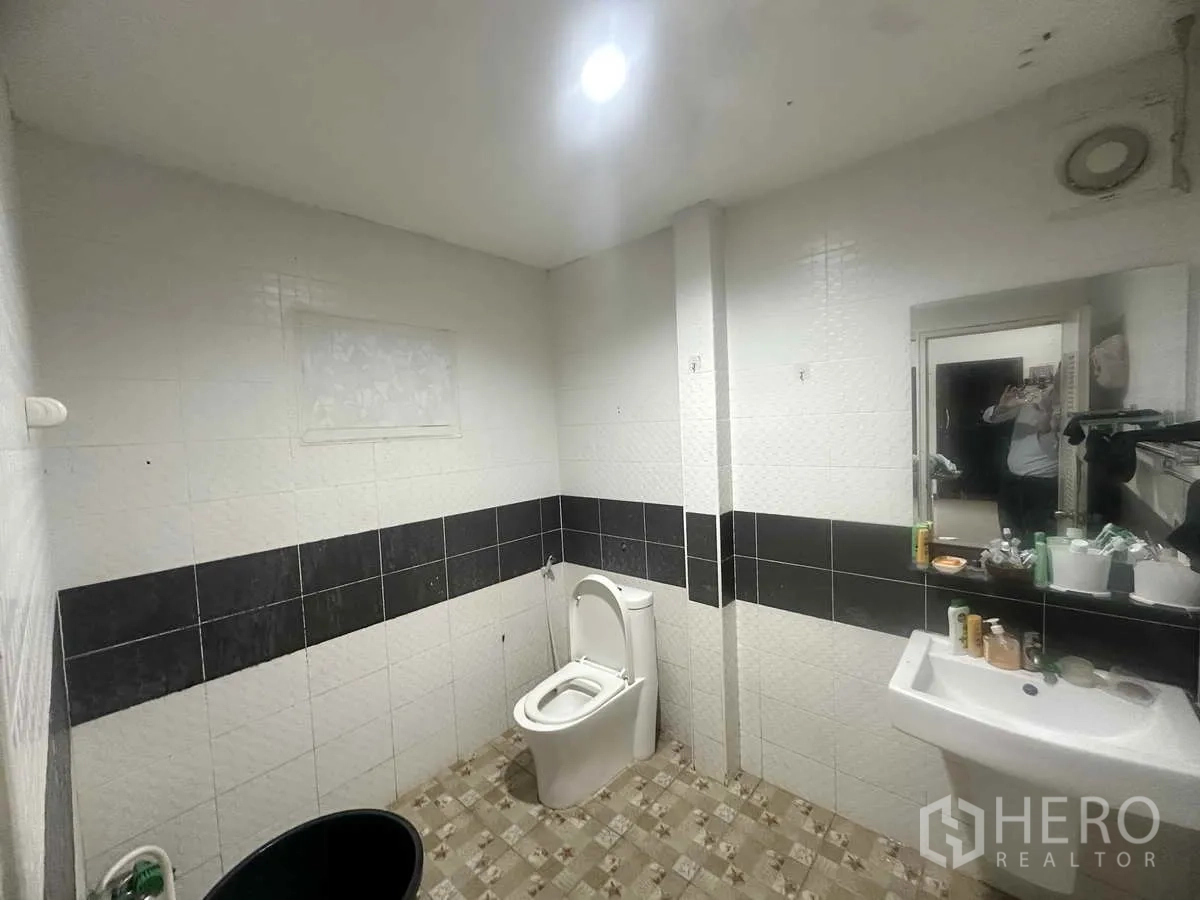 独立式住宅 出售在Pathum Thani - 瓷砖卫生间，坐便器、洗手盆与排风扇。