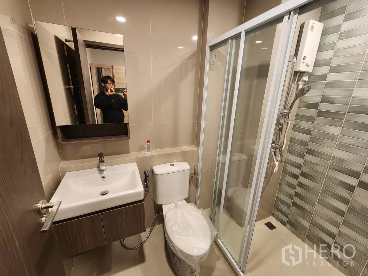 Townhouse for rent in Khlong Toei, Bangkok - Modern bathroom with glass shower enclosure, vanity and toilet.