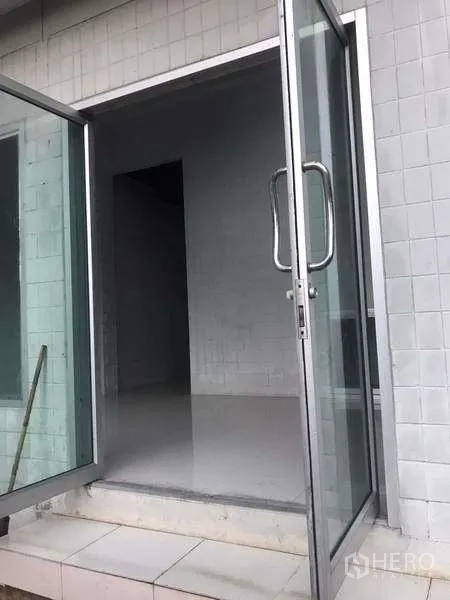 Warehouse for rent in Pathum Thani - Ground-floor glass double doors opening to clean tiled entry room