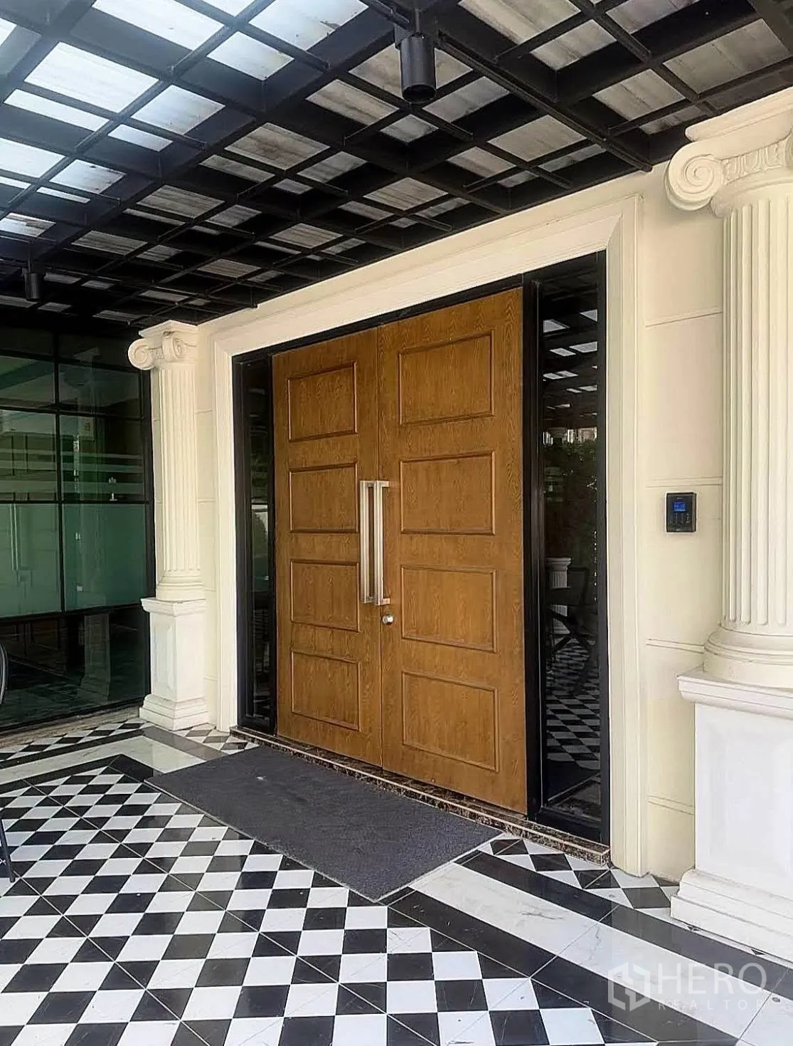 家庭办公室 for rent in Lat Phrao, Bangkok - 带顶门廊与原木双开门的入口，地面为黑白棋盘格瓷砖。
