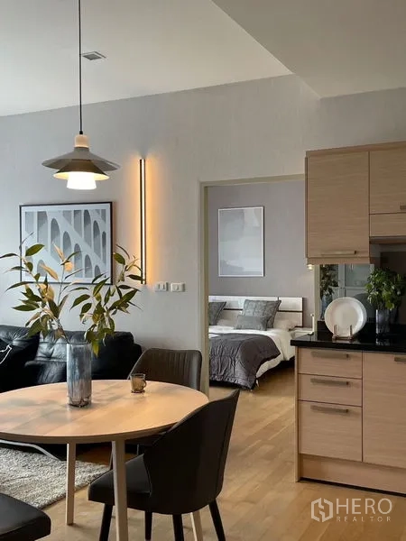 คอนโด ให้เช่าในWatthana, Bangkok - มองจากโต๊ะอาหารไปยังทางเข้าห้องนอน ข้างโซฟาสีดำและครัว