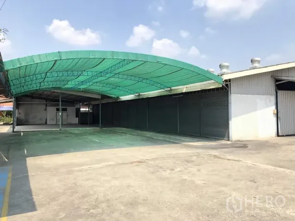 คลังสินค้า ให้เช่าในKhlong Luang, Pathum Thani - ลานขนถ่ายสินค้ามีหลังคาผ้าใบสีเขียว พร้อมประตูม้วนหลายช่องข้างตัวโกดัง