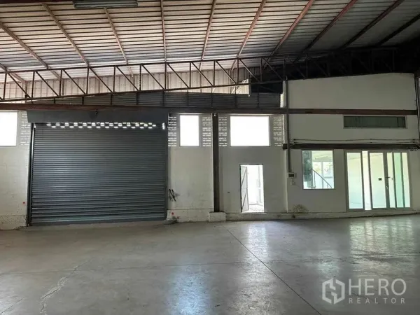 คลังสินค้า ให้เช่าในNakhon Pathom - ภายในโกดังโปร่งพื้นคอนกรีตขัดมัน หลังคาโครงเหล็กสูง พร้อมประตูม้วนขนาดใหญ่