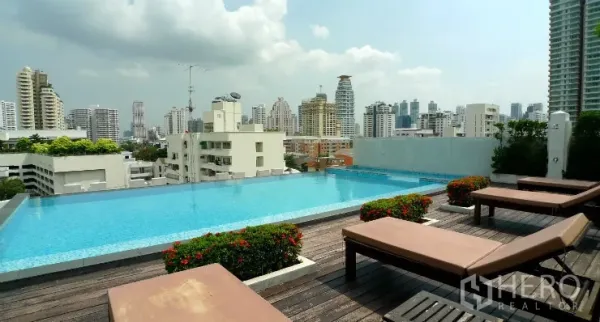 公寓 出售在Watthana, Bangkok - 屋顶无边泳池，设躺椅，俯瞰曼谷วัฒนา区天际线。