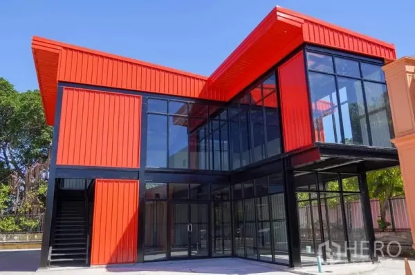 零售空间 出租在Bang Na, Bangkok - 红色外立面与通高玻璃窗的两层零售建筑，位于邦纳。