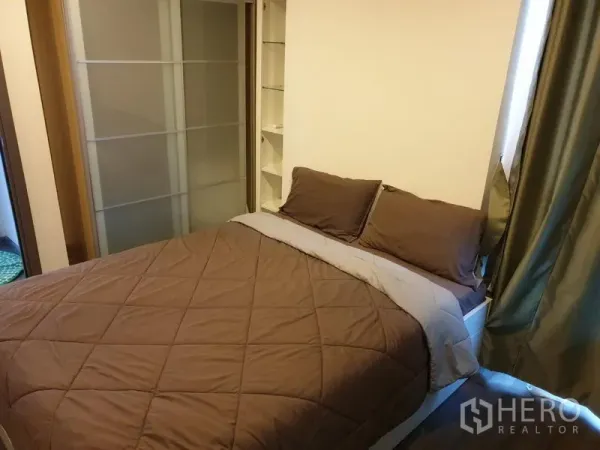 Condominium for rent in Watthana, Bangkok - Master bedroom with double bed, brown bedding, sliding wardrobe, and shelving.