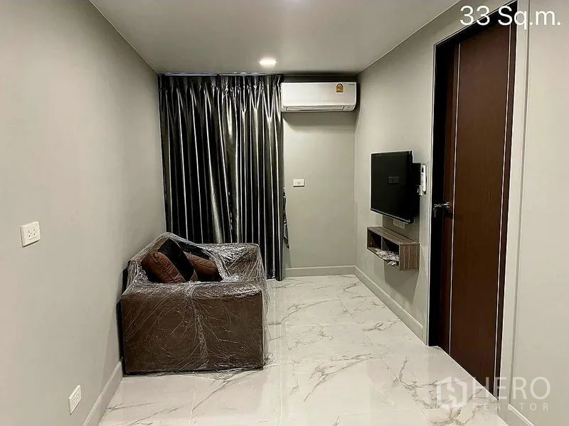 零售空间 出售在Khlong Toei, Bangkok - 温馨客厅，沙发、电视、空调与仿大理石地砖。