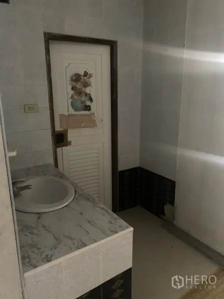 店屋 出租在Khlong Toei, Bangkok - 瓷砖卫生间，带仿石台面洗手盆与白色门。