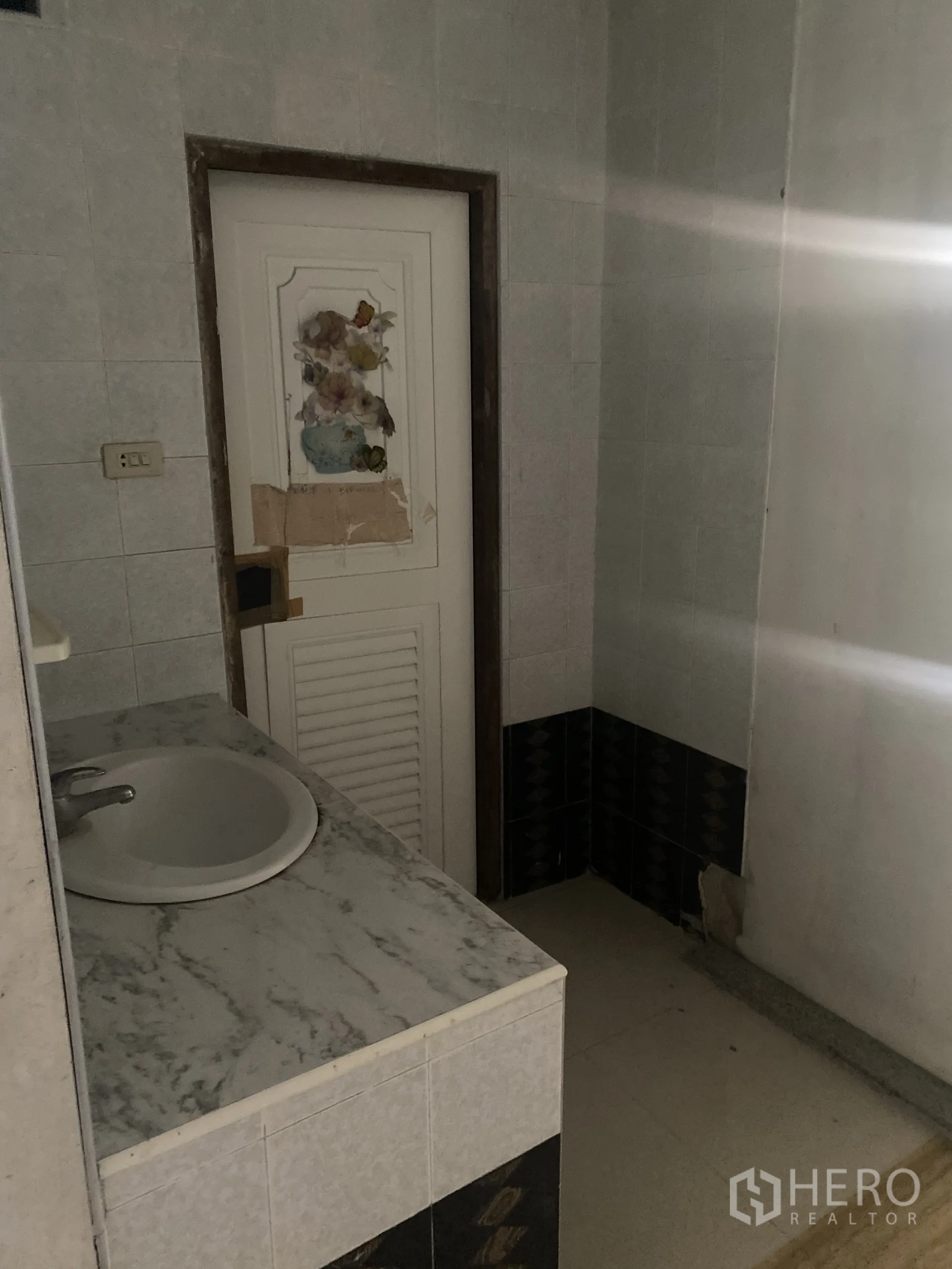 店屋 出租在Khlong Toei, Bangkok - 瓷砖卫生间，带仿石台面洗手盆与白色门。
