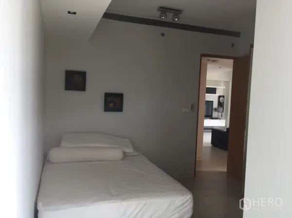 Condominium for rent in Sathon, Bangkok - Cozy guest bedroom with simple furnishings and view toward the living area.