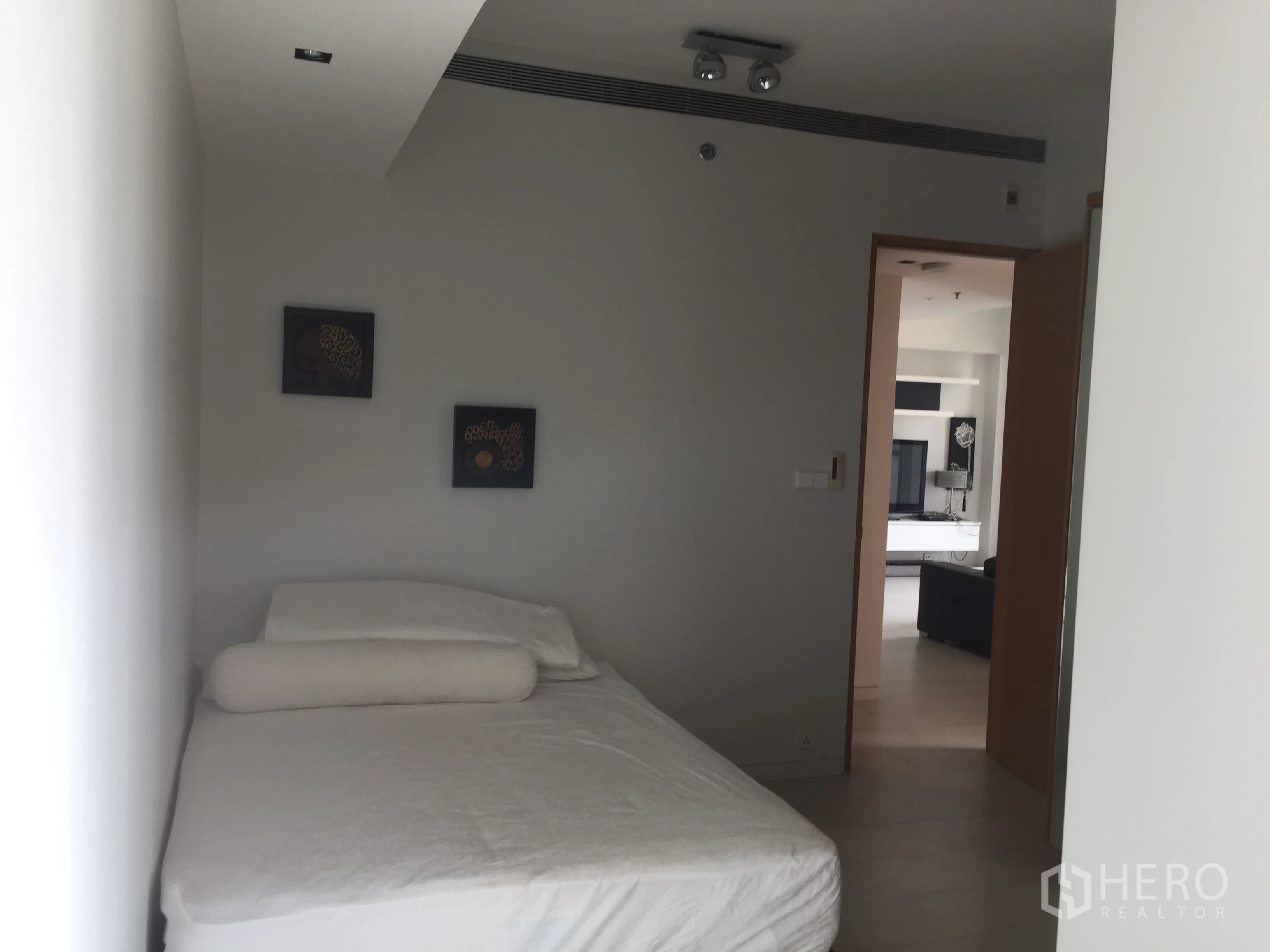 Condominium for rent in Sathon, Bangkok - Cozy guest bedroom with simple furnishings and view toward the living area.