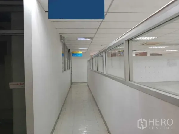Office Space for rent in Watthana, Bangkok - Interior hallway with glass partitions and tiled floor beside the open office area.