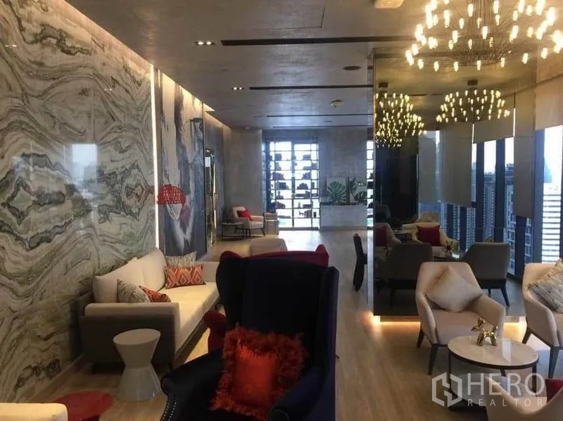 คอนโด ให้เช่าในDin Daeng, Bangkok - เลานจ์ส่วนกลางพร้อมโซฟา โคมไฟระย้า และวิวเมืองจากหน้าต่างบานใหญ่