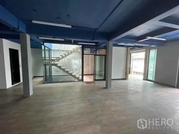 สำนักงาน ให้เช่าในWatthana, Bangkok - พื้นที่สำนักงานเปิดโล่ง เพดานสีน้ำเงิน พื้นลายไม้ และแกนบันไดกระจก