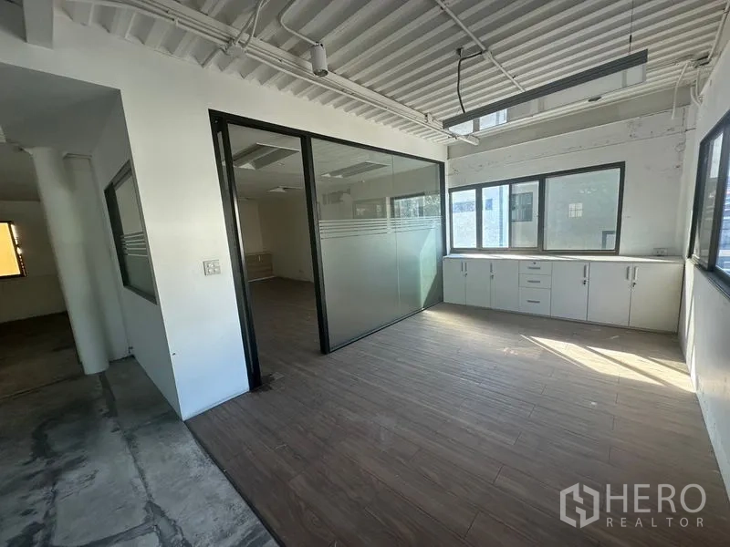 Warehouse for rent in Saphan Sung, Bangkok - Corner office with sliding glass partition and multiple windows.