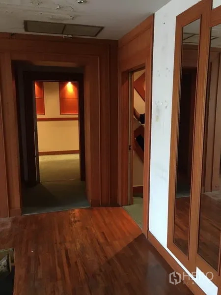 零售空间 出租在Watthana, Bangkok - 走廊设镜面与木饰面，通向展示空间。