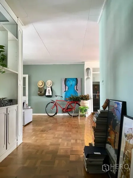Apartment for rent in Khlong Toei, Bangkok - Wide corridor with parquet flooring, mint walls, bicycle and artwork creating a stylish entry area.