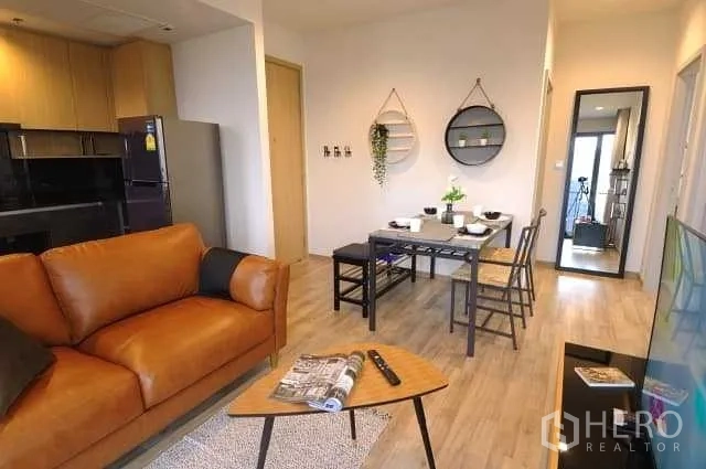 公寓 出租或出售在Chatuchak, Bangkok - 开放式客餐厅，皮沙发、精致厨房与木质地板