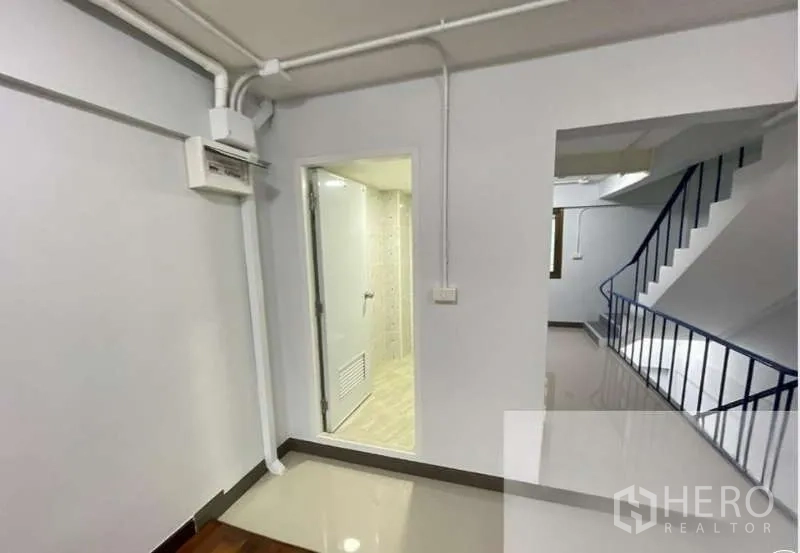 อาคารพาณิชย์ ขายในSuan Luang, Bangkok - ห้องขนาดกะทัดรัด พร้อมประตูเข้าห้องน้ำปูกระเบื้อง และบันไดราวสีน้ำเงิน