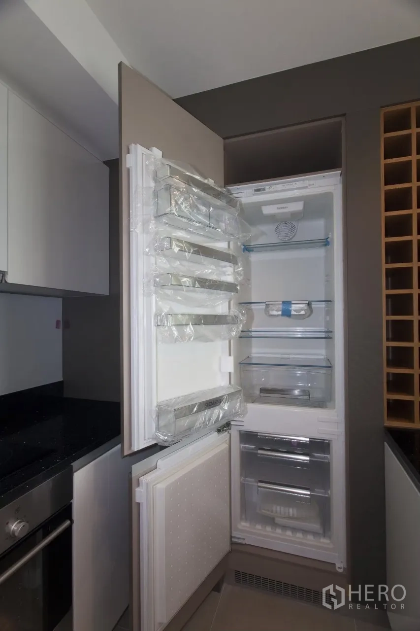 คอนโด ให้เช่าหรือขายในKhlong San, Bangkok - ตู้เย็นบิลท์อินแบบสูงเปิดโชว์ช่องเก็บของ ข้างชั้นเก็บไวน์