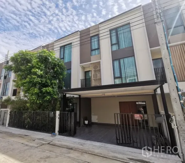 Townhouse for rent in Bang Phli, Samut Prakan - Three-storey modern townhouse facade with covered carport, gate and tall windows in Bang Phli.