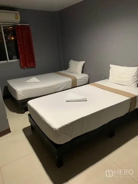 พื้นที่ขายปลีก ให้เช่าในKhlong Toei, Bangkok - ห้องเตียงเดี่ยวสองเตียง ผนังสีเทา มีหน้าต่างและเครื่องปรับอากาศ