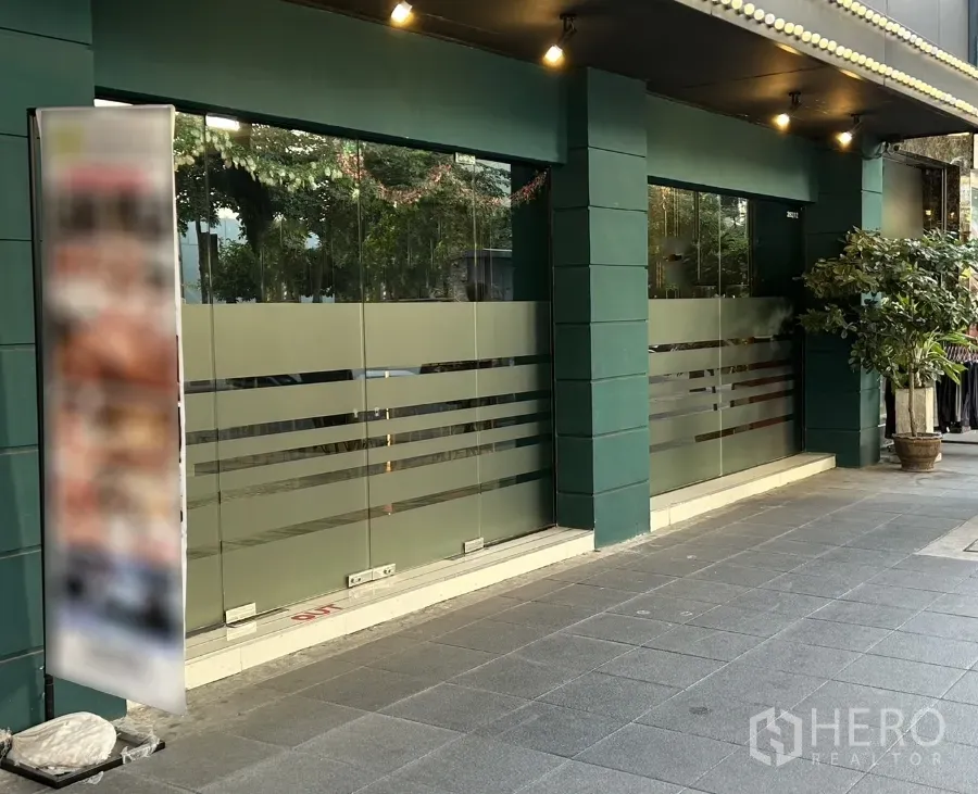 พื้นที่ขายปลีก ให้เช่าในKhlong Toei, Bangkok - หน้าร้านชั้นล่างกระจกบานใหญ่ เสาโทนเขียว และทางเดินมีหลังคา ในย่านสุขุมวิท คลองเตย