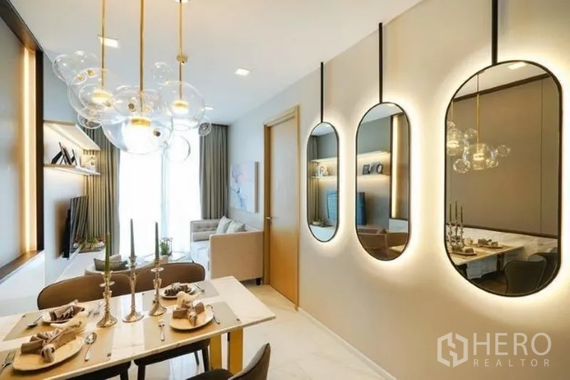 คอนโด ให้เช่าในWatthana, Bangkok - มุมทานข้าวโต๊ะหินอ่อนสำหรับสี่ที่นั่ง โคมไฟแก้วทรงฟองอากาศ และกระจกติดผนังมีไฟแบ็กไลท์สามบาน