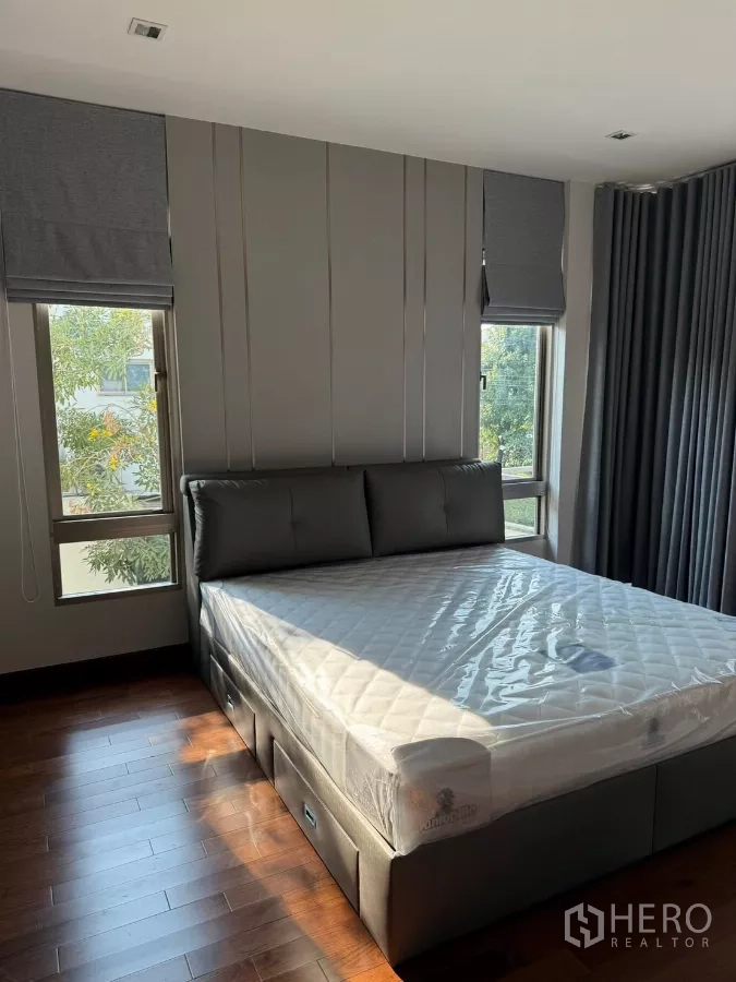 独立式住宅 出租在Bang Phli, Samut Prakan - 卧室配大软包床、木地板与双侧窗户