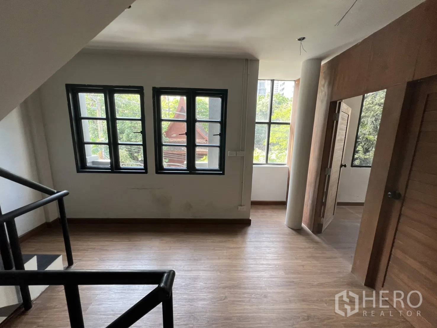 店屋 出租在Watthana, Bangkok - 楼梯平台区，设窗与房门，可见室外绿意。