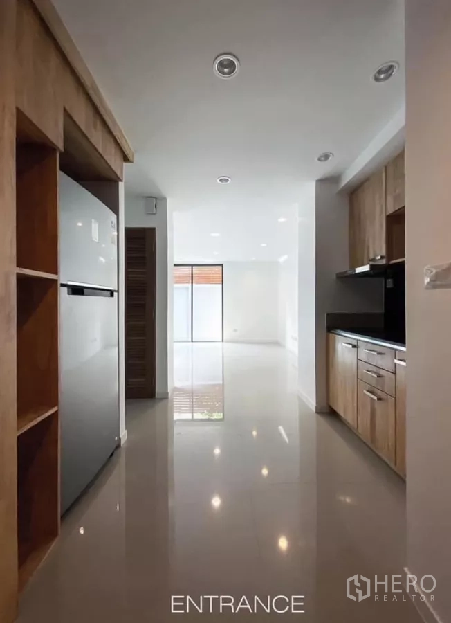 Detached House for rent in Huai Khwang, Bangkok - Bright entrance hall leading to open-plan living with recessed lighting and tiled floors; kitchen to the right.