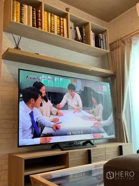 公寓 出租或出售在Phra Khanong, Bangkok - 客厅电视墙，内置搁架与大型平面电视。